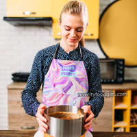 woman-baking-cake-wearing-feelin-frosty-cake-frosting-rainbow-tie-dye-apron-with-white-straps-and-all-over-frosted-icing-print-available-from-novelty-food-gifts-dot-com